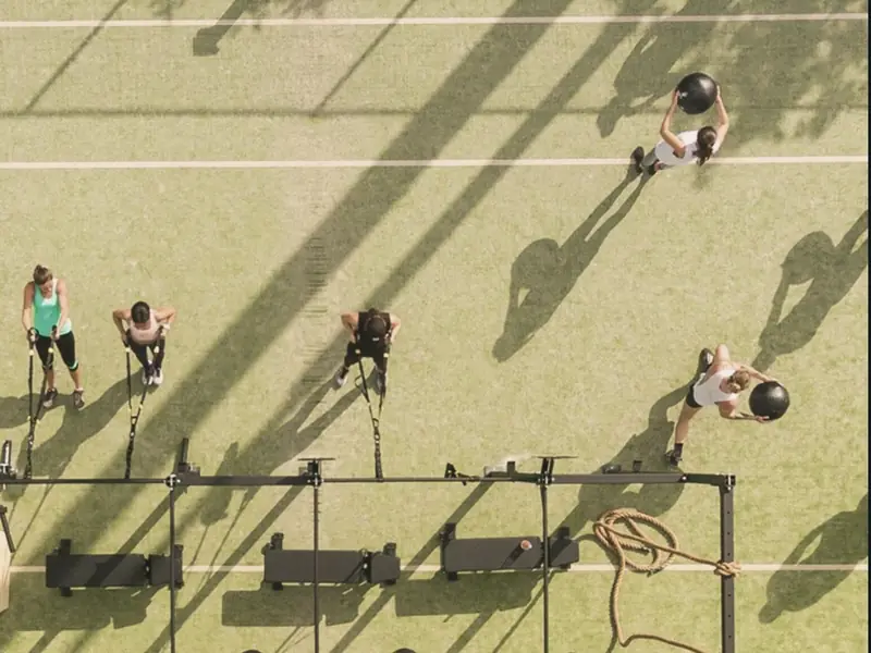 Grupo entrenando al aire libre sobre el pasto con luz de tarde